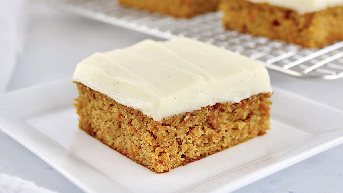 Carrot Cake Bar on white square plate with cooling rack in back