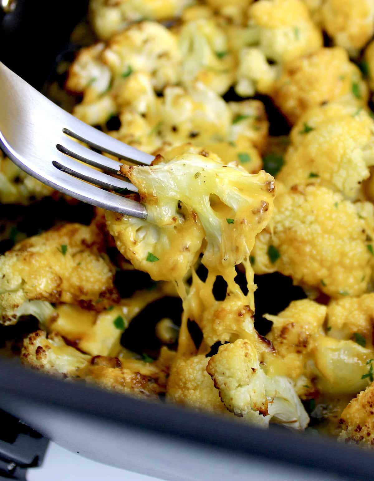 Air Fryer Cheesy Cauliflower with fork pulled piece with cheese