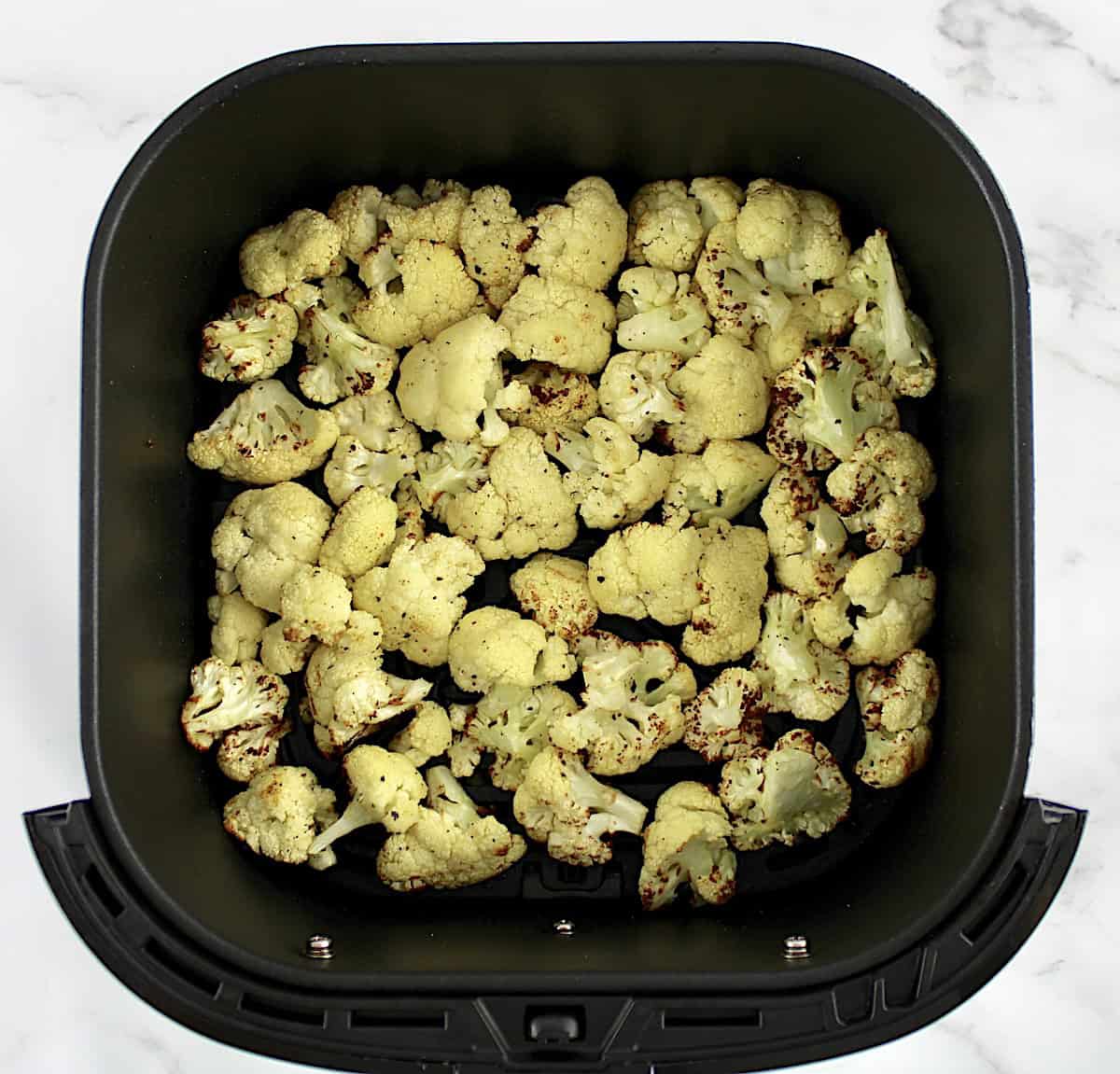 roasted cauliflower florets in air fryer basket