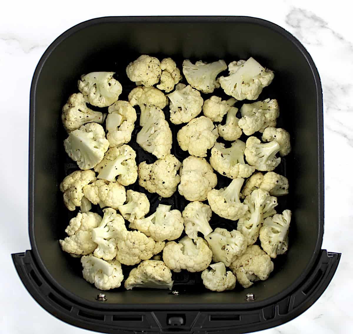 cauliflower florets, olive oil, garlic salt and pepper  in air fryer basket