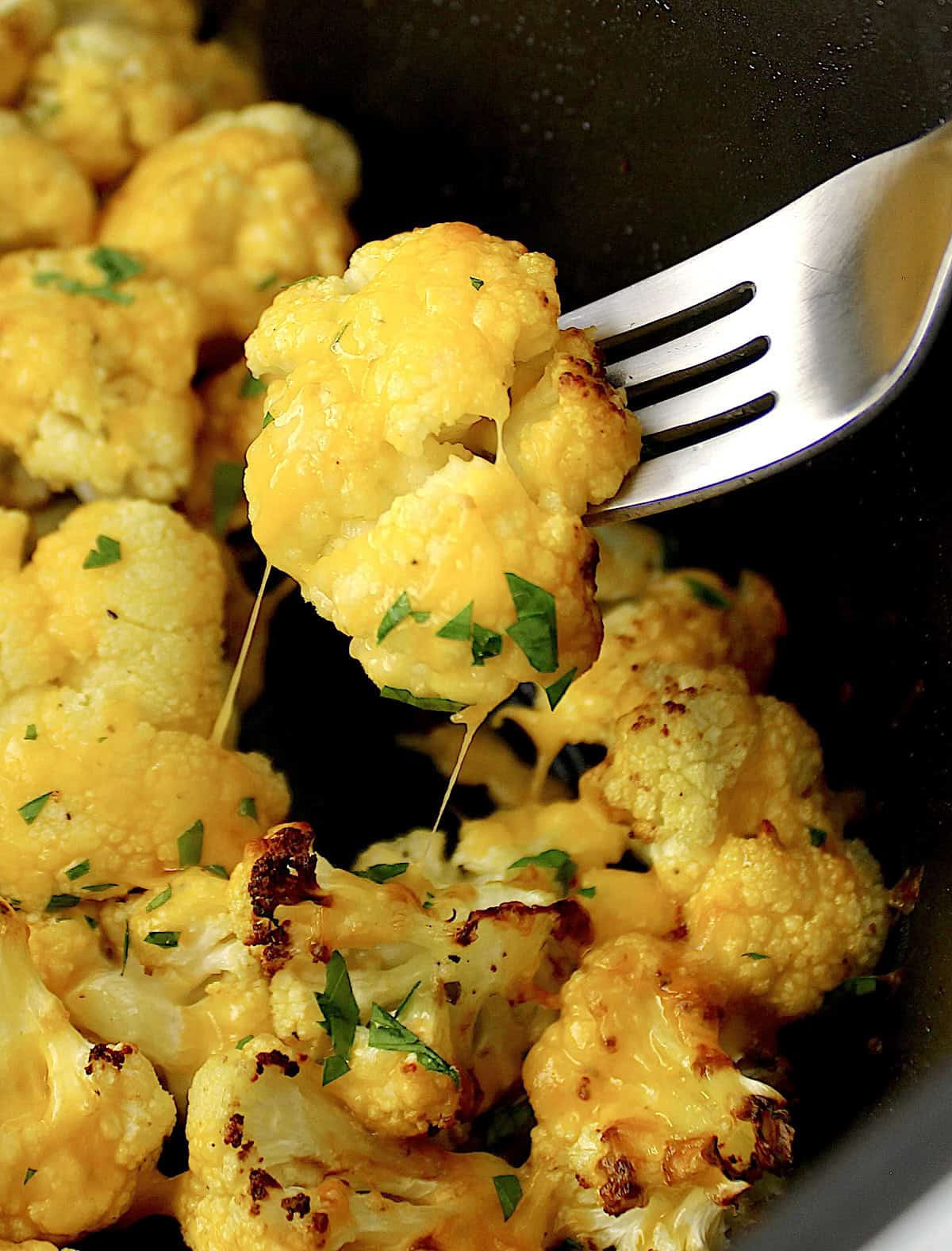 Air Fryer Cheesy Cauliflower with fork pulled piece with cheese