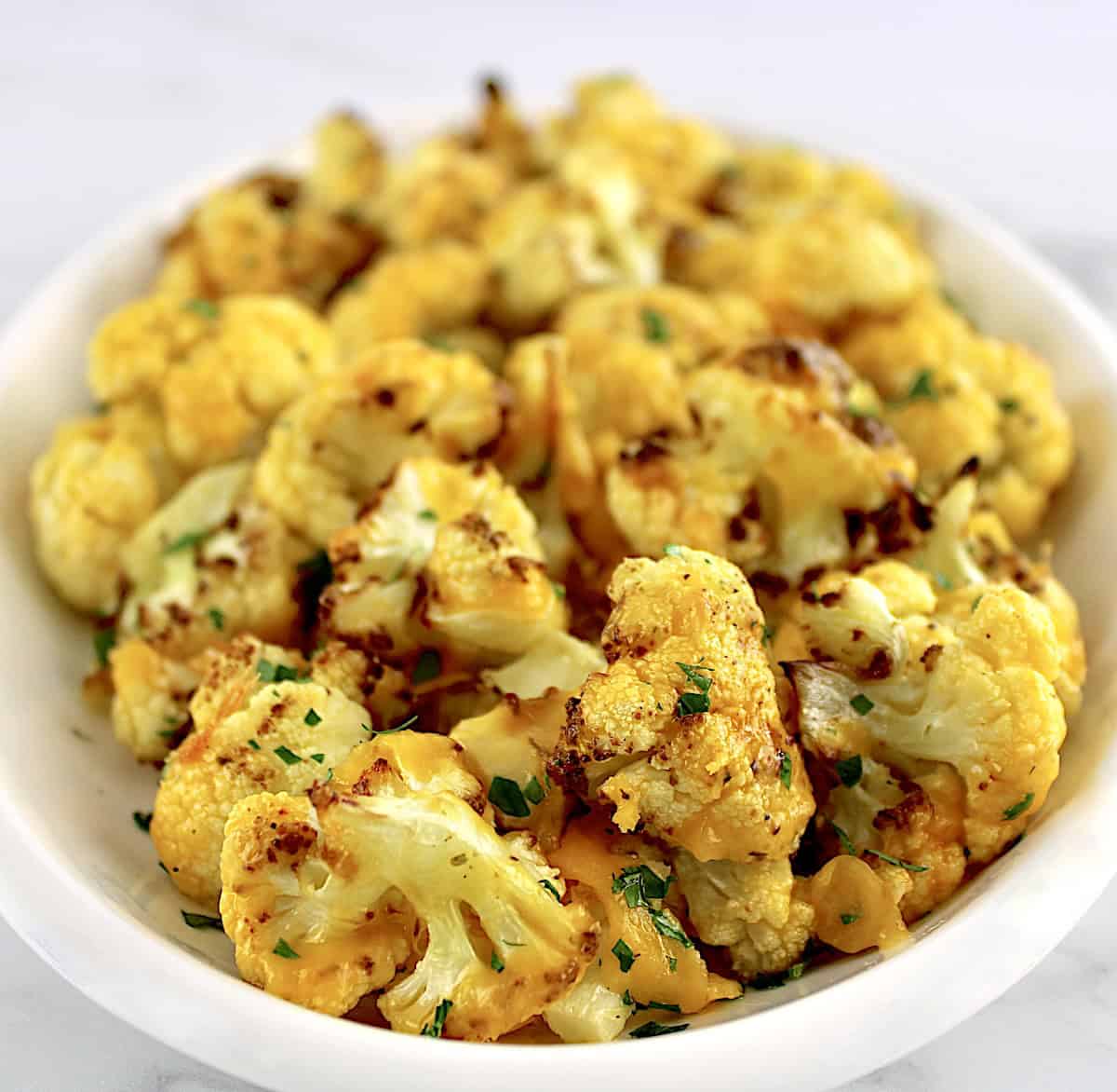 closeup of Air Fryer Cheesy Cauliflower on white oval platter