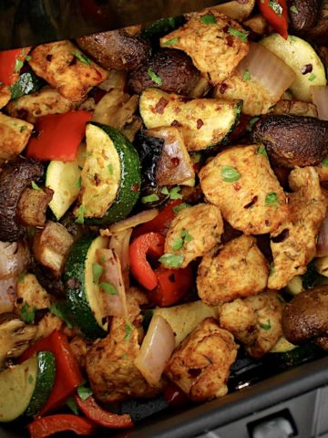 Air Fryer Chicken Bites and Veggies in air fryer basket with chopped parsley