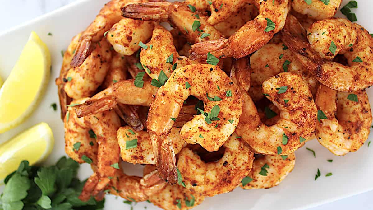 Air Fryer Frozen Shrimp on white plate with lemon and parsley