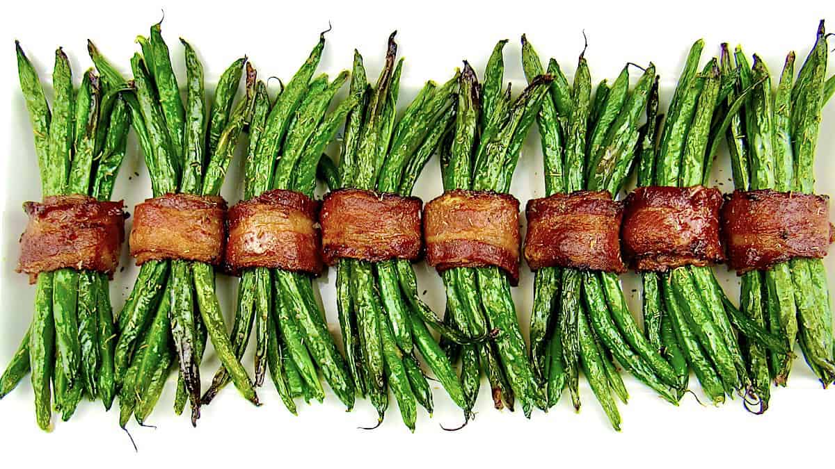 bacon wrapped green beans on white plate