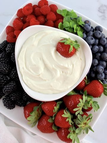 Easy Fruit Dip in white bowl with berries all around the sides