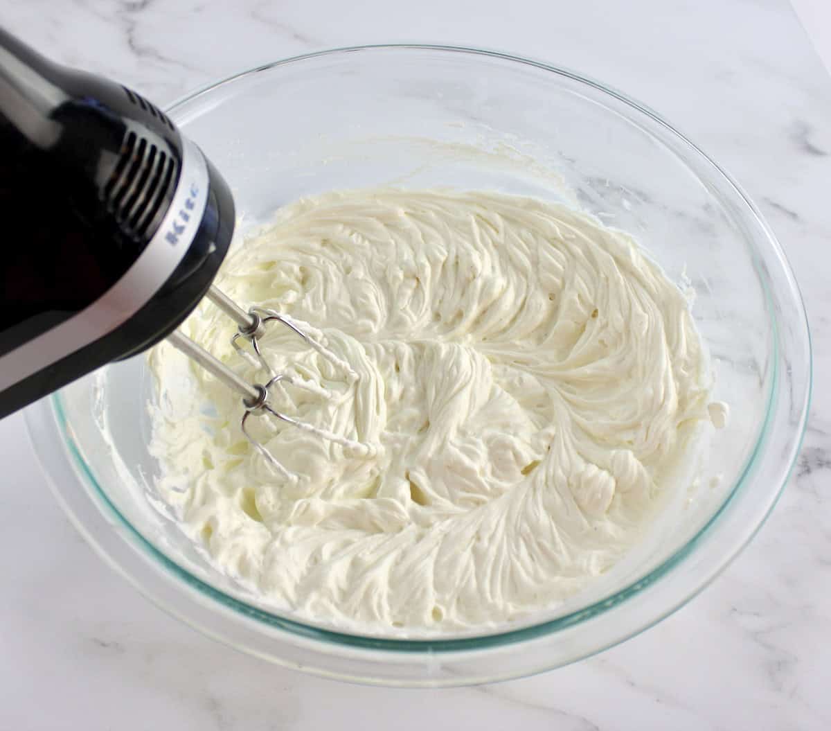 Easy Fruit Dip in glass bowl with hand mixer