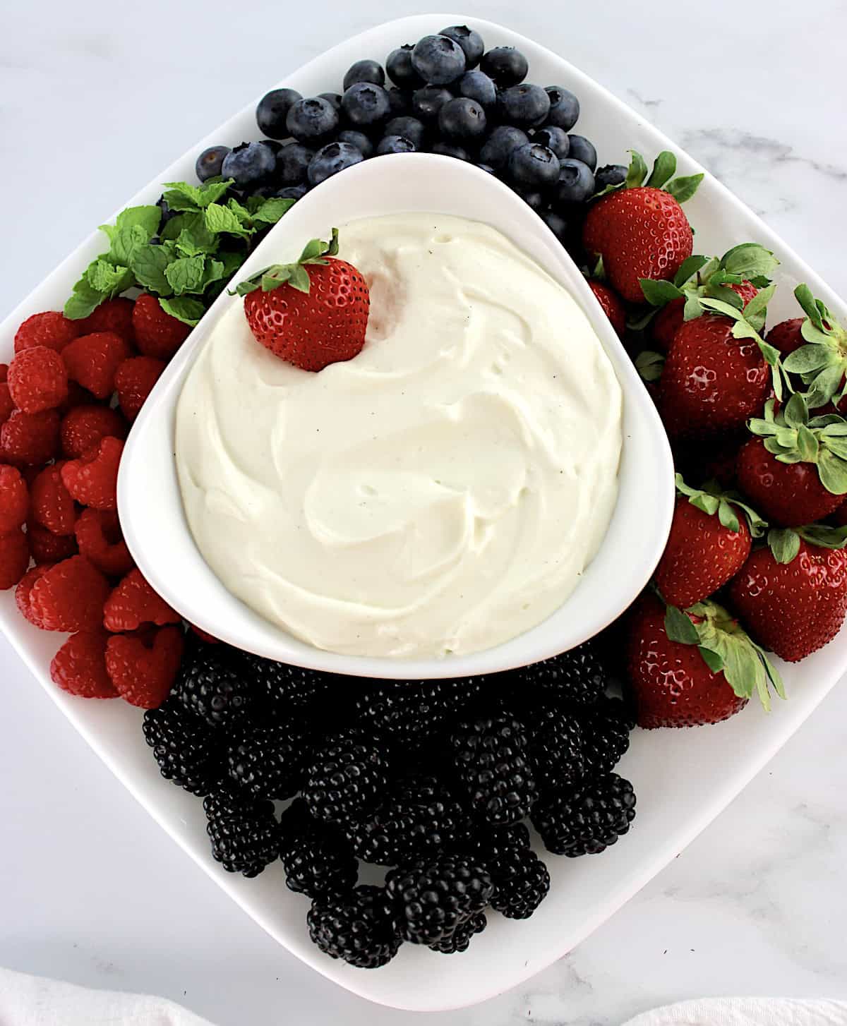 Easy Fruit Dip in white bowl with fresh berries all around