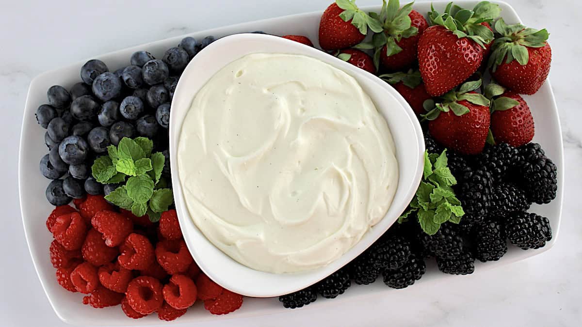 Easy Fruit Dip in white bowl with berries all around