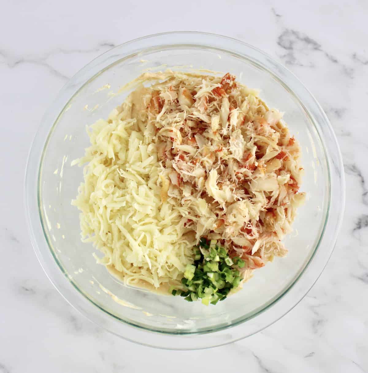 Hot Crab Dip ingredients, mozzarella, scallions and crab meat in glass bowl