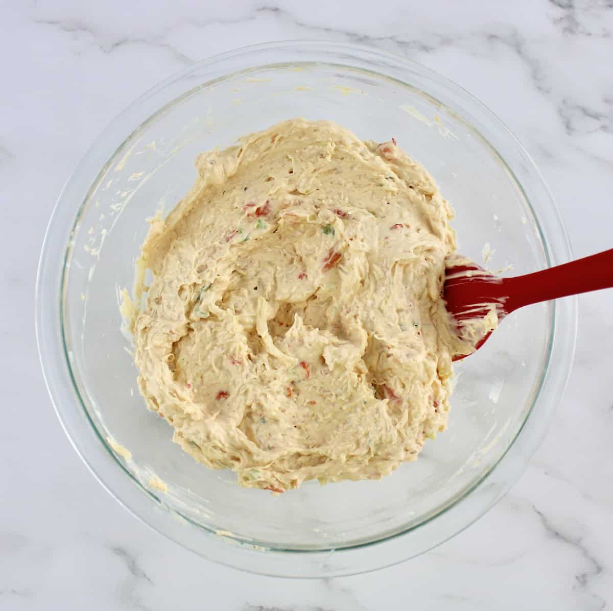 Hot Crab Dip in glass bowl with red spoon