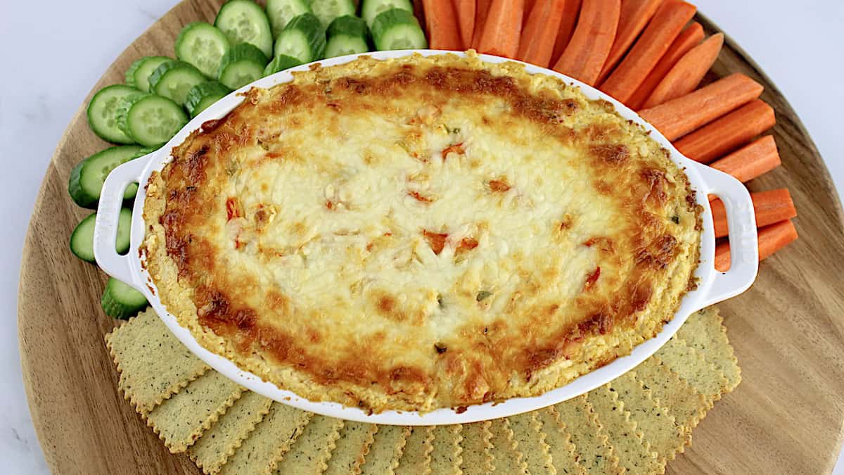 Hot Crab Dip with crackers, carrot sticks and cucumber slices around