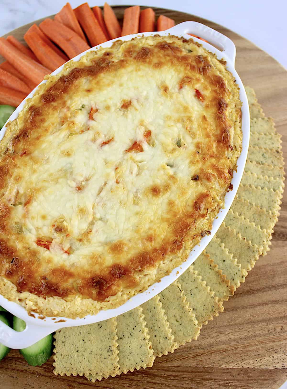 Hot Crab Dip in white oval casserole with keto crackers on side