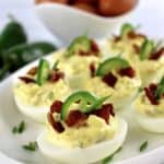 Jalapeño Popper Deviled Eggs on white platter with eggs in back