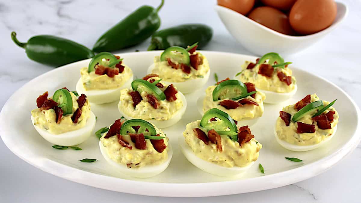 Jalapeño Popper Deviled Eggs on oval white platter with eggs in back