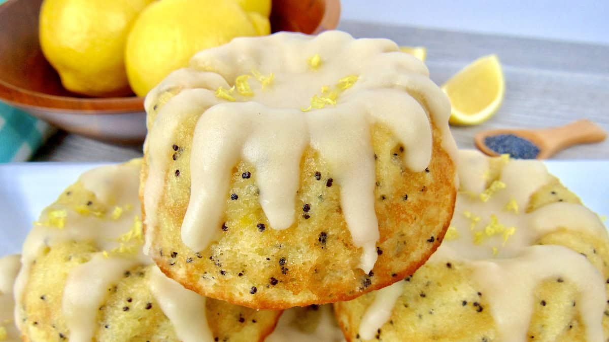 closeup of Keto Lemon Poppy Mini Bundt Cakes with icing dripping down from the tops