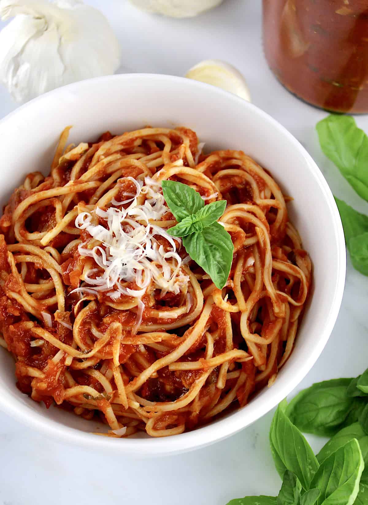 palmini with Keto Marinara Sauce in white bowl with grated parmesan and fresh basil