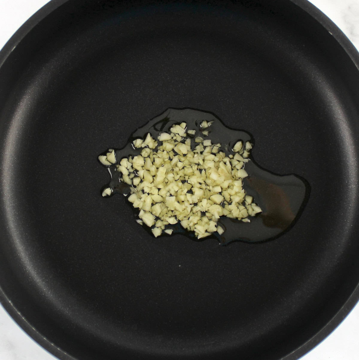 saucepan with minced garlic and olive oil