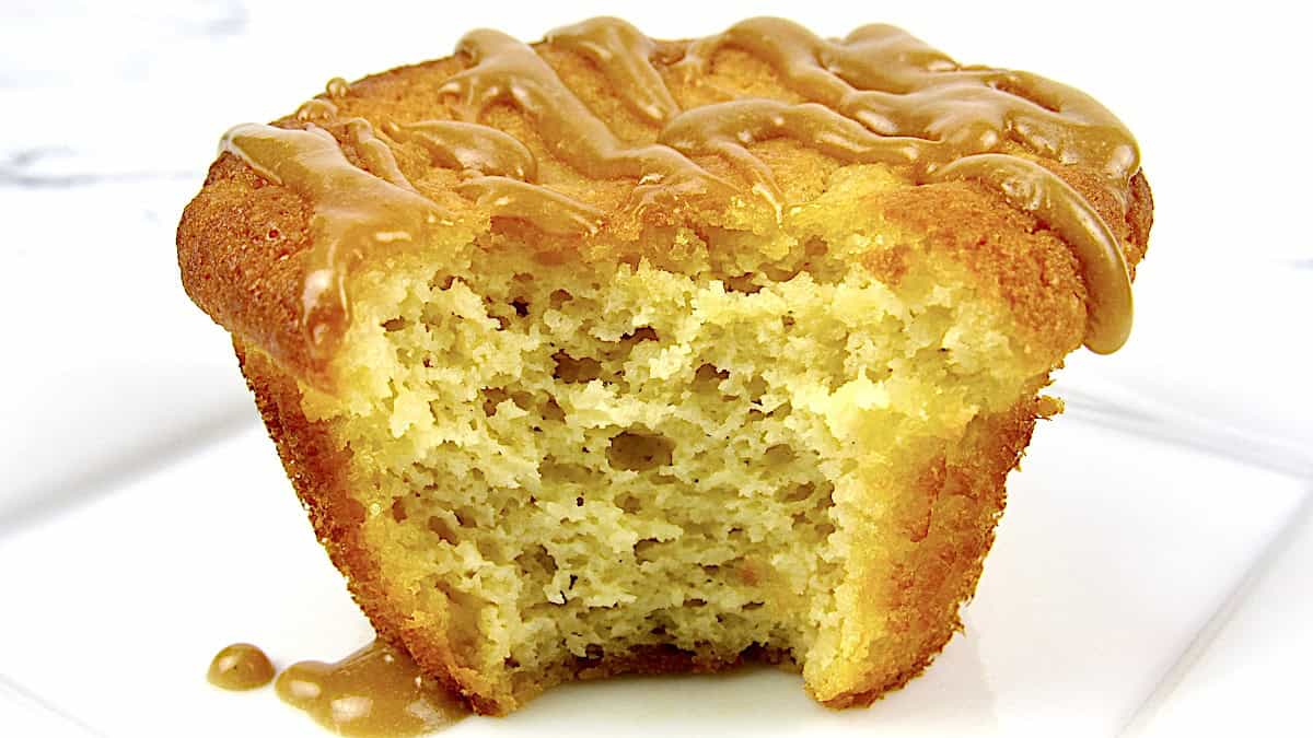 closeup of salted caramel muffin on white plate with bit missing