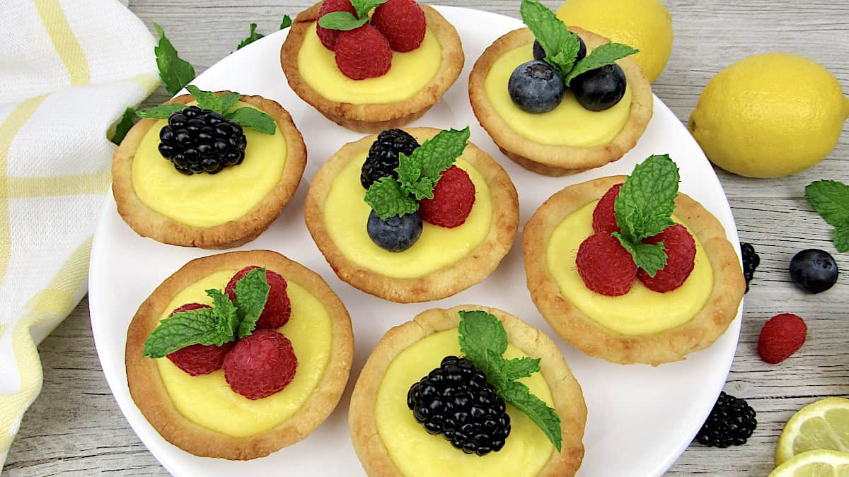 7 mini lemon curd tarts with berries on top