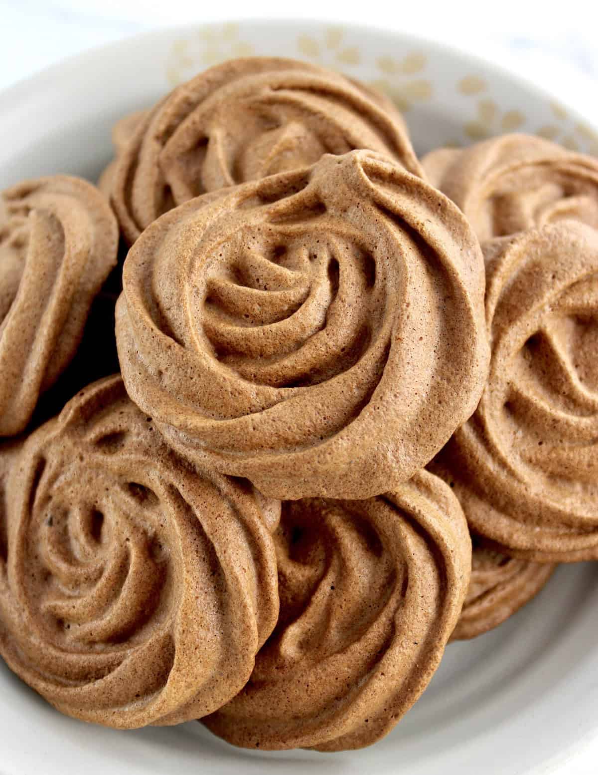 closeup of Mocha Meringue Cookies piled up in beige bowl