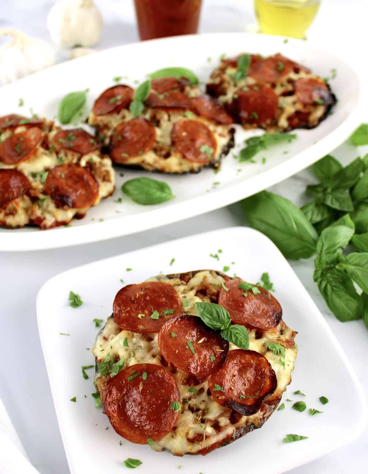 Portobello Mushroom Mini Pizza on white plate with 3 more in background on platter