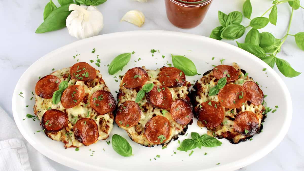 3 Portobello Mushroom Mini Pizzas on white oval platter with basil garnish