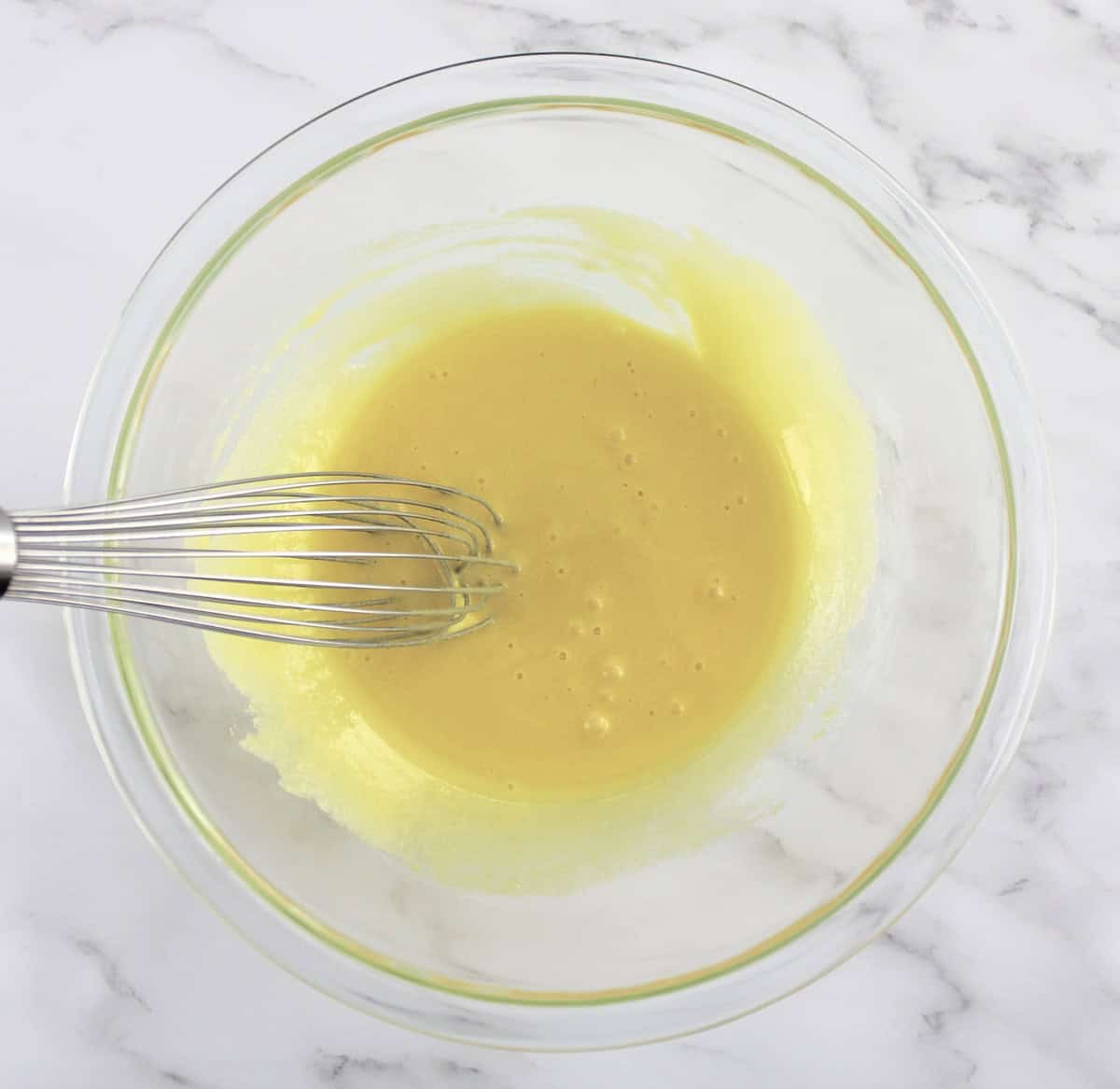 eggs and sweetener whisked in glass bowl