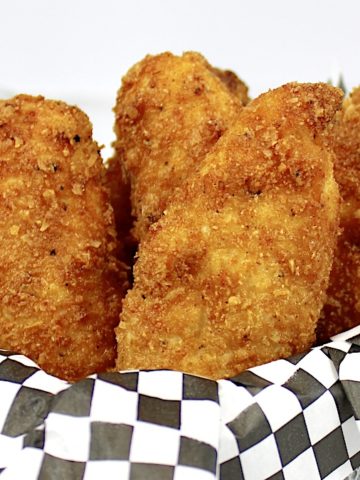 closeup of chicken tenders in white dish with honey mustard on side