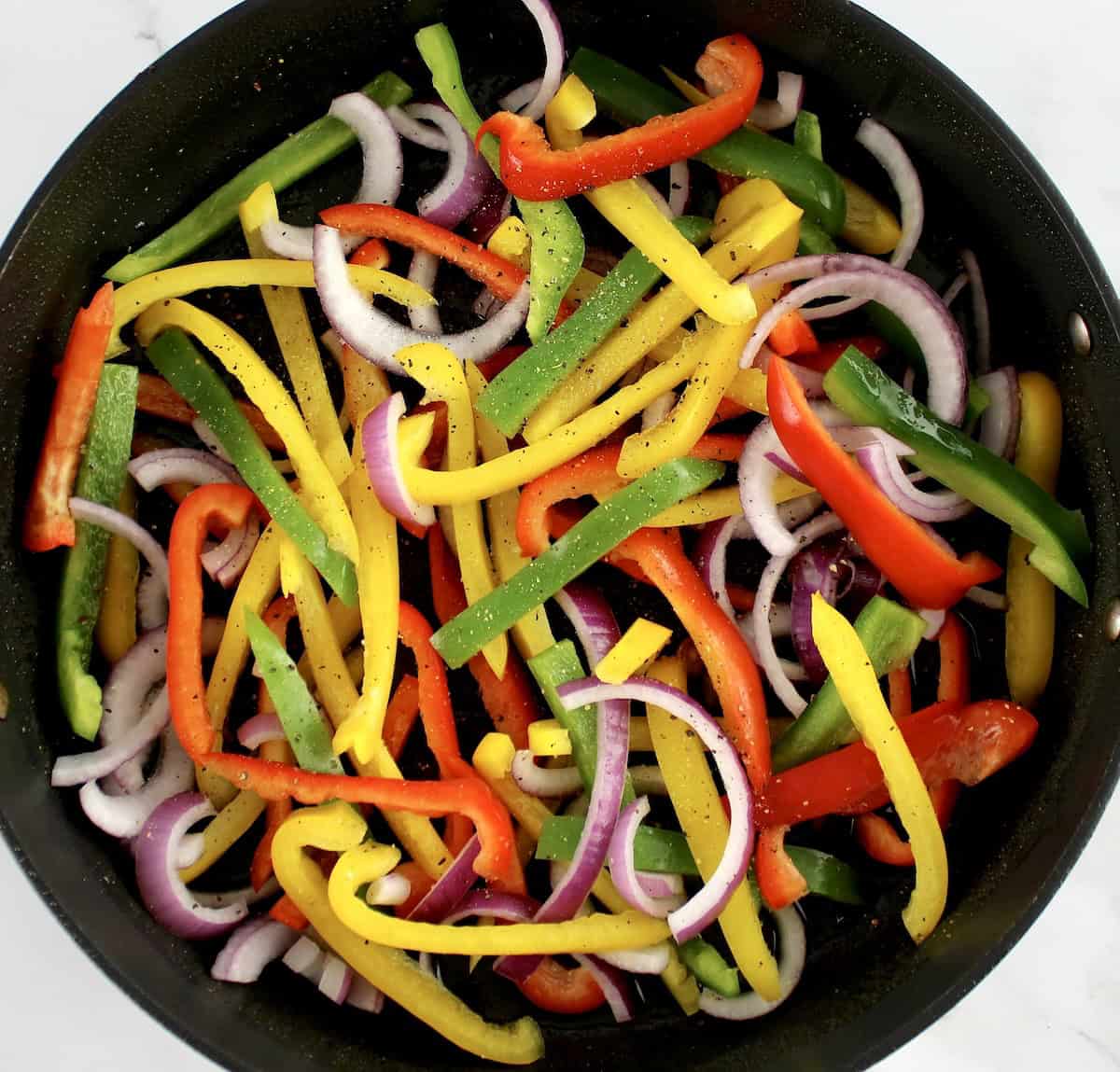 bell peppers mix and sliced red onions in skillet