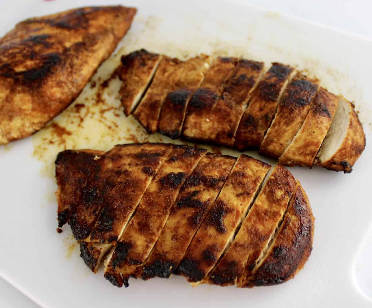 fajita seasoned chicken sliced on cutting board