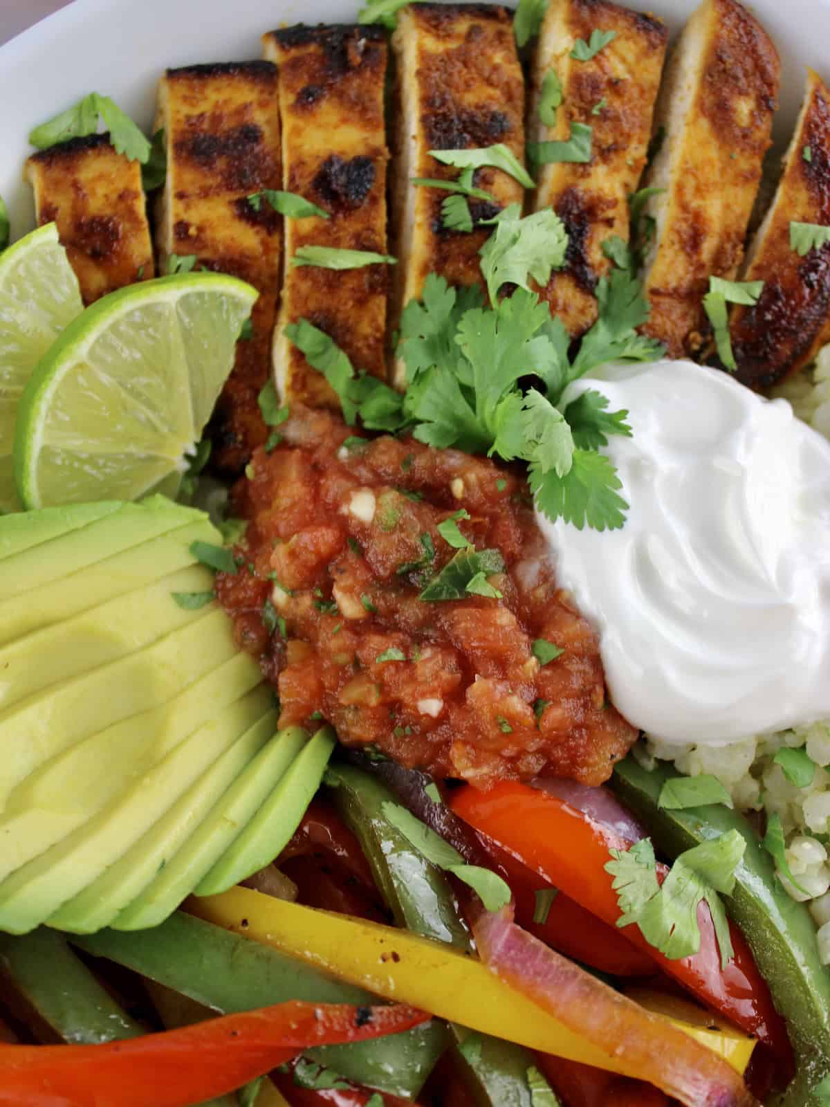 closeup of Chicken Fajita Bowl with dollop of sour cream and salsa