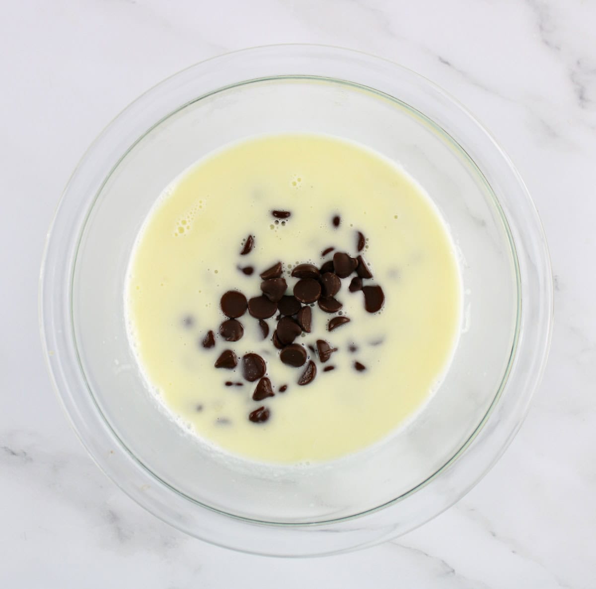 hot cream and chocolate chips in glass bowl unmixed