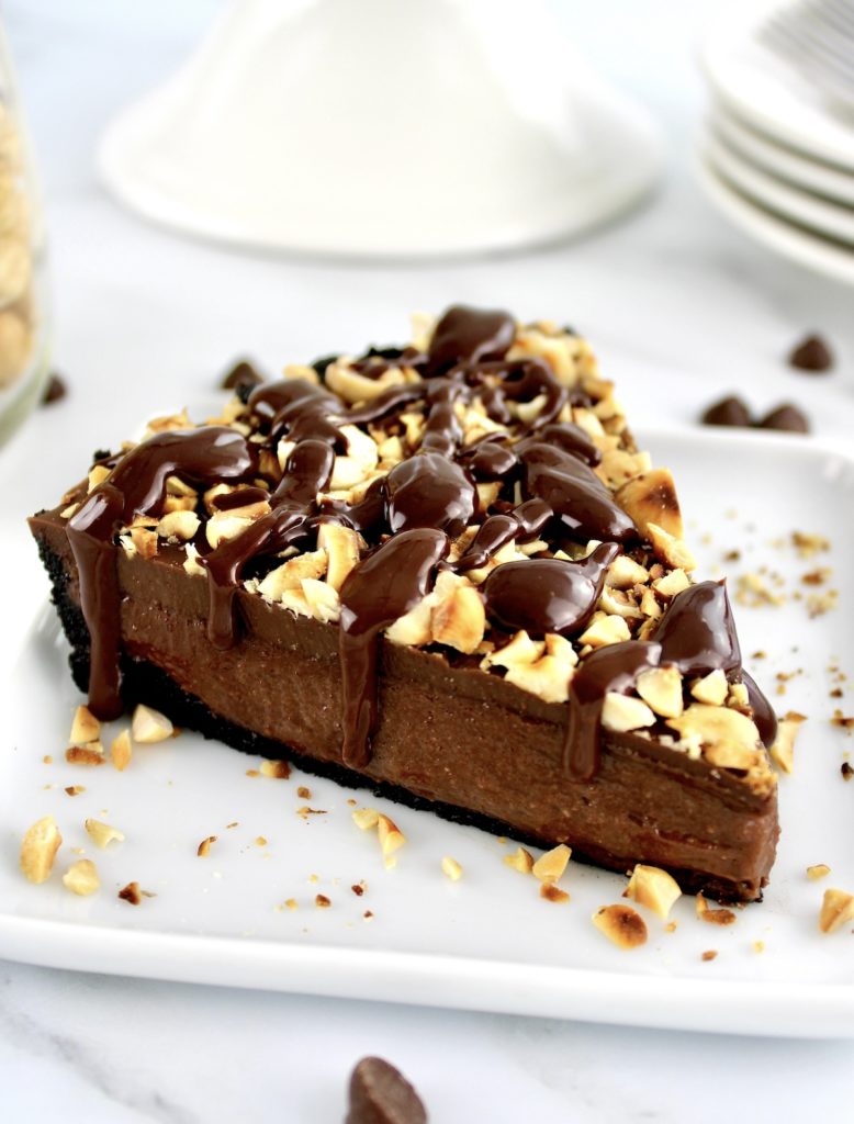 closeup of slice of Chocolate Hazelnut Tart on white plate
