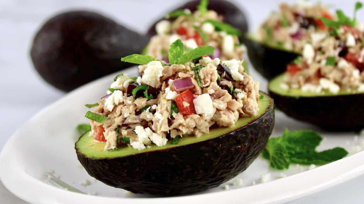 closeup of Greek Tuna Stuffed Avocados on white oval plate