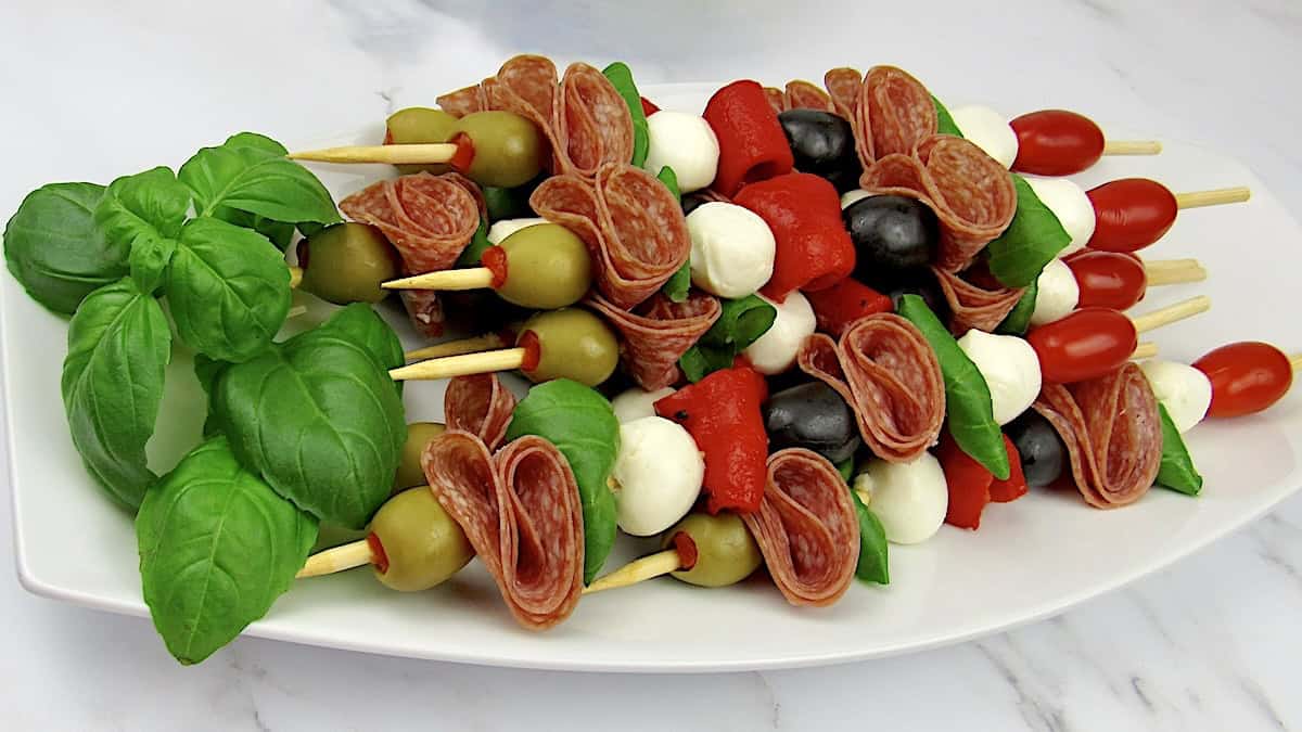 overhead view of Italian antipasti skewers on white platter