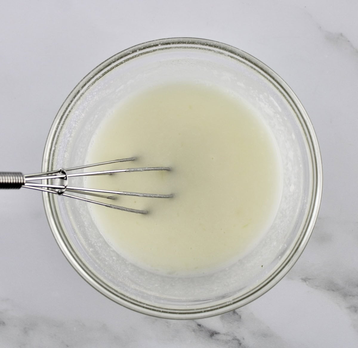 lemon glaze in glass bowl with whisk