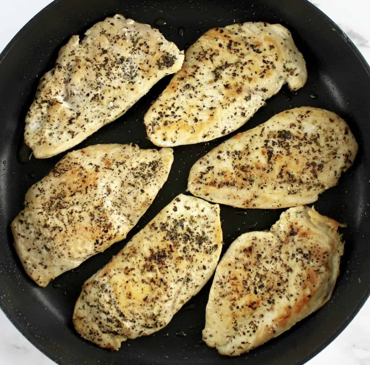 6 pieces of chicken breast with herbs cooked in skillet