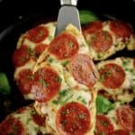 Pizza Chicken being held up with silver spatula over skillet