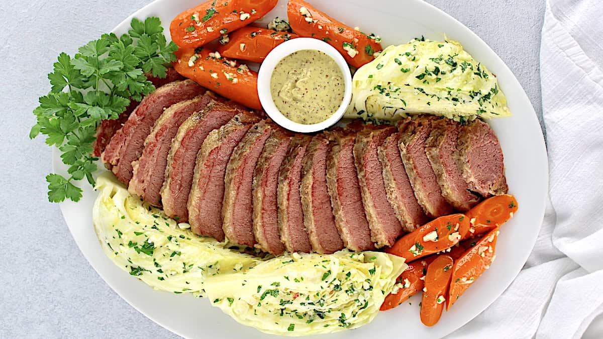 sliced corned beef cabbage and carrots on white platter