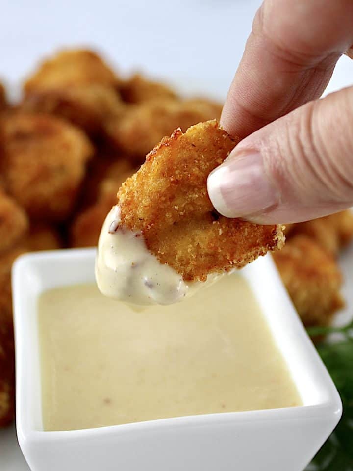 Air Fryer Chicken Nugget held up after dipping in honey mustard sauce