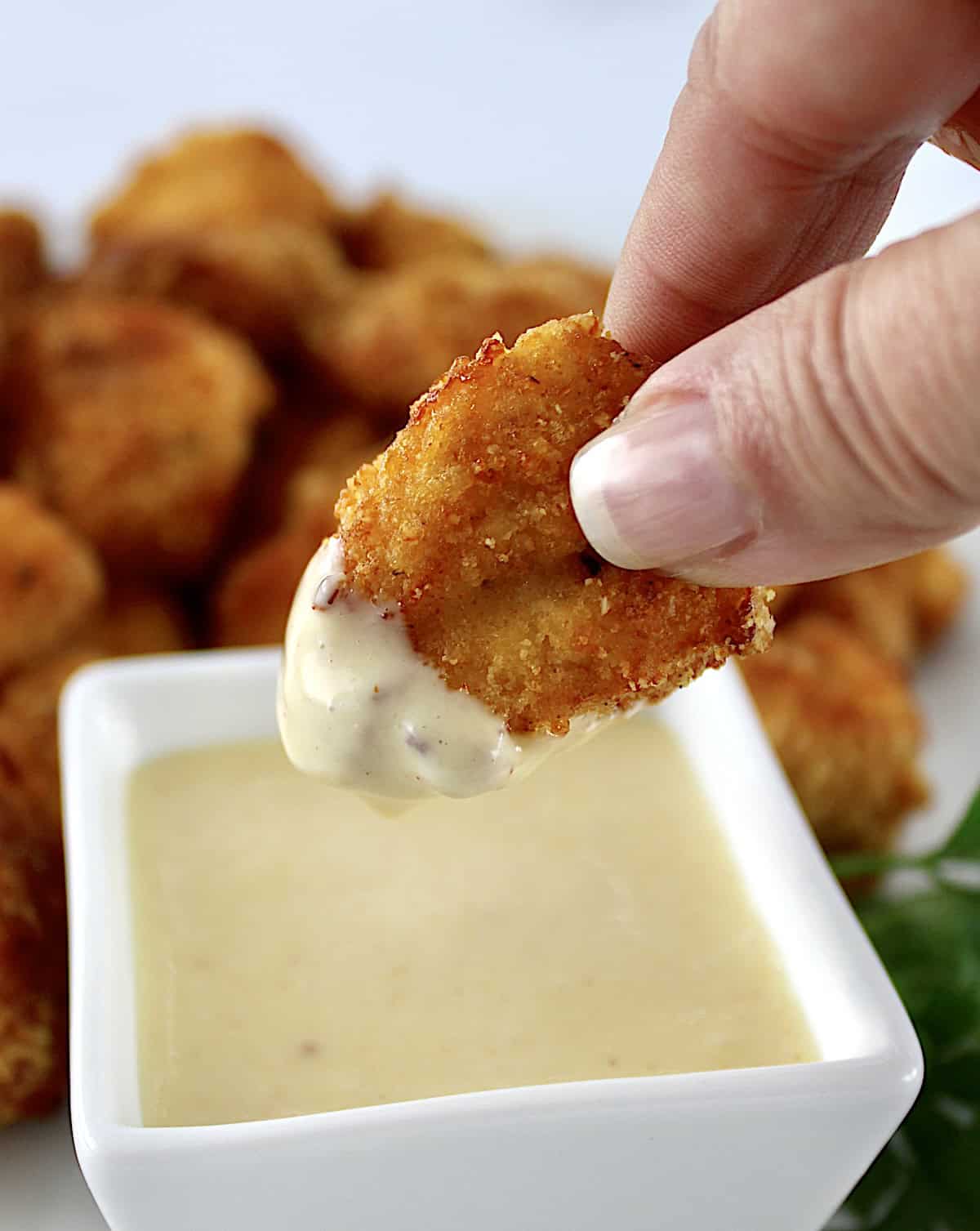 Air Fryer Chicken Nugget held up after dipping in honey mustard sauce