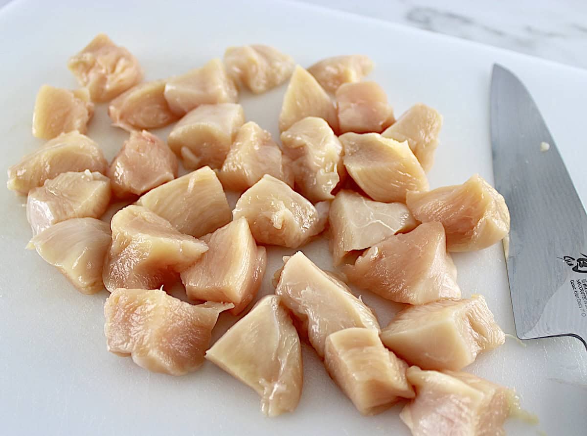 chicken breast on white cutting board cut into nuggets