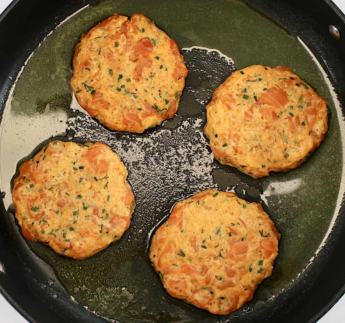 4 raw Boom Boom Salmon Burger in skillet