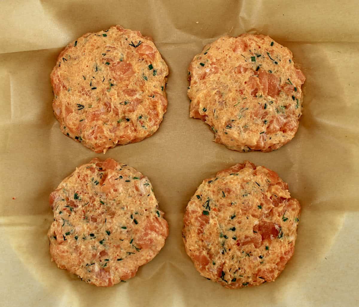 4 Boom Boom Salmon Burger patties uncooked on parchment paper