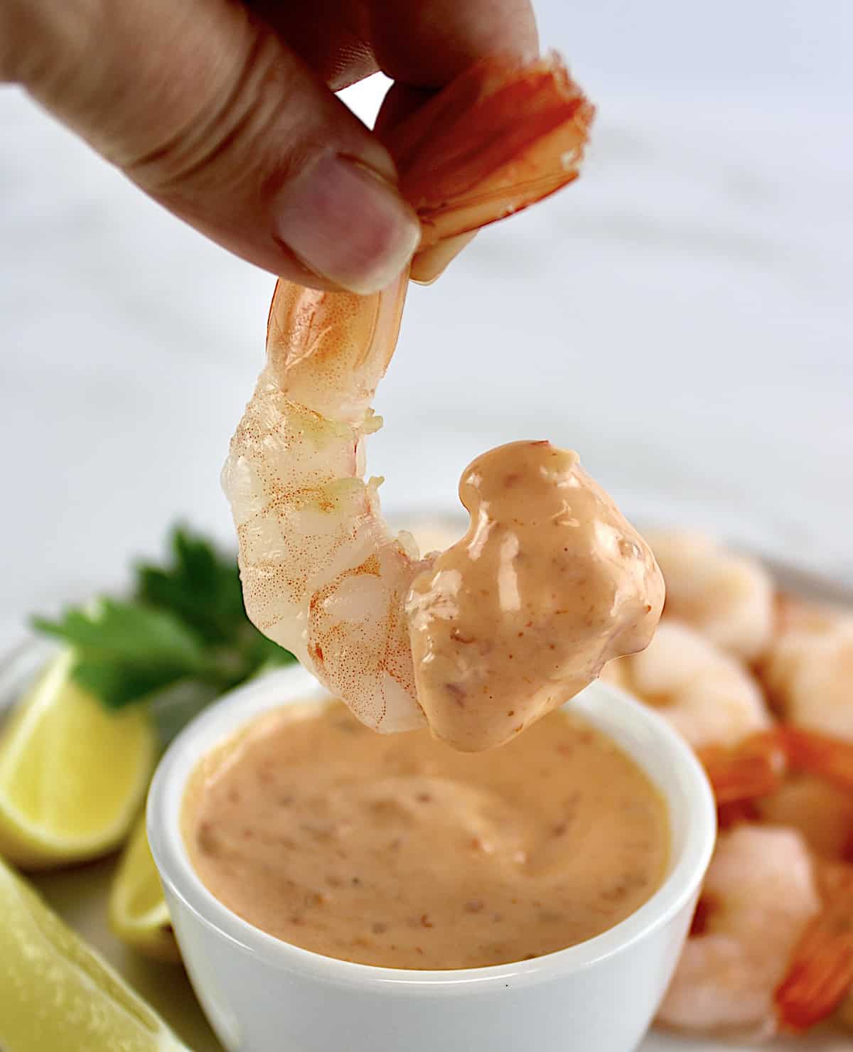 holding up shrimp dipped in boom boom sauce