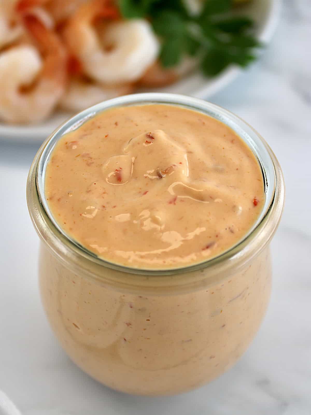 closeup of Boom Boom Sauce in open glass jar with shrimp in back