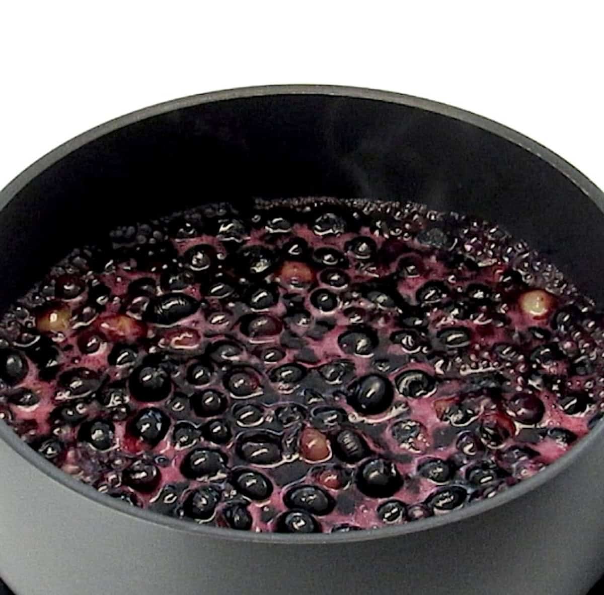 Keto Blueberry Sauce in saucepan simmering