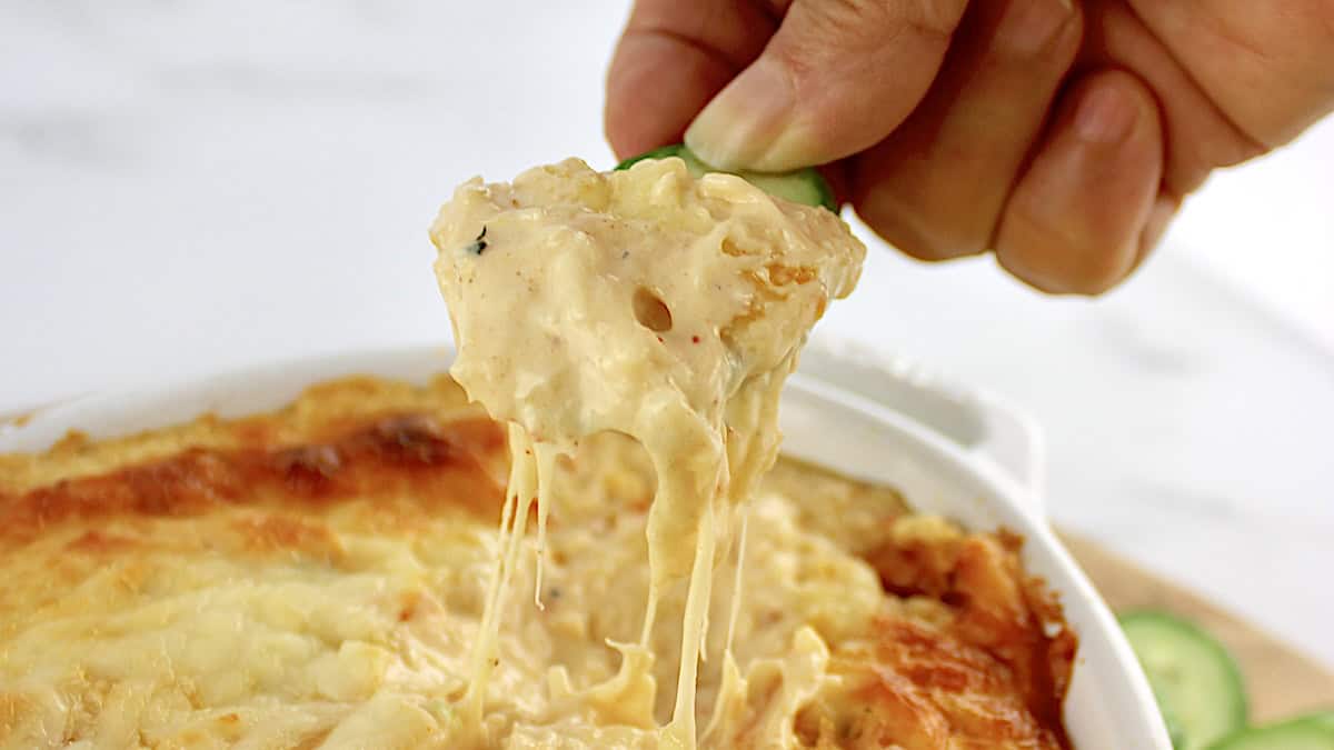 hot crab dip being pulled up with cheese pull