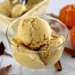 3 scoops of No-Churn Pumpkin Ice Cream in glass dish with more ice cream in back